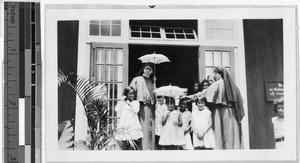 Two Maryknoll Sisters standing in a doorway with a group of girls, Heeia, Hawaii, 1932
