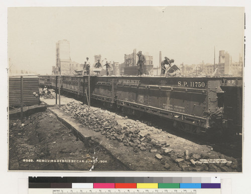 Removing debris by car, June 7[?], 1906. [Southern Pacific Railroad cars loaded with rubble and workers on top.]