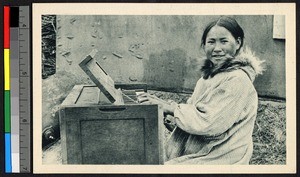 A young female organist is shown seated indoors before a small organ, Alaska, ca.1920-1940