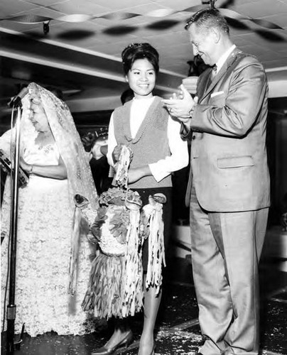 Consuelo Bonzo with a man and a woman holding a pinata onstage