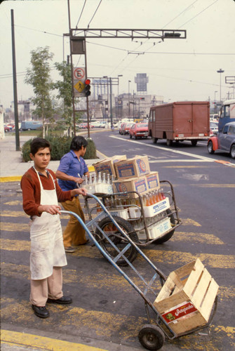 Two young men transport crates of soda, Mexico, ca. 1983