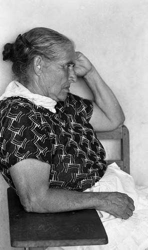 An older woman sits at a desk, Nicaragua, 1980