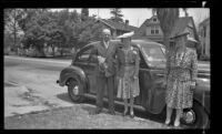 H. H. West, Mertie West and Josie Shaw pose near a car parked in front of H. H. West's residence, Los Angeles, 1943