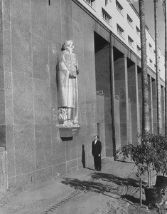 Kenneth Hahn looking at a gilded statue of Moses on the Los Angeles County Hall of Administration