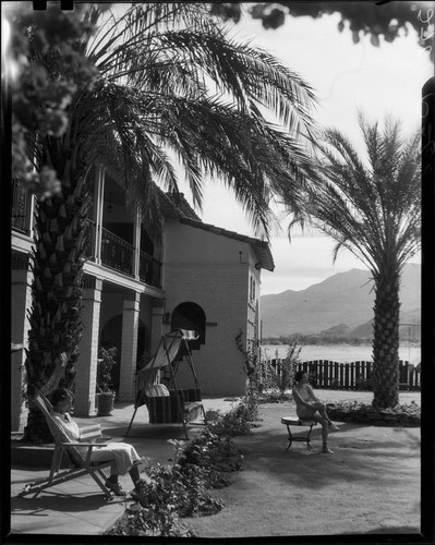 Ann Pruden and Mary Conners in outdoor area with palm trees, Palm Springs, 1940