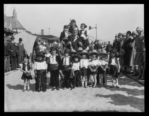 Troupe picture of Meglin Kiddies with a man in front of Gables Beach Club, Santa Monica