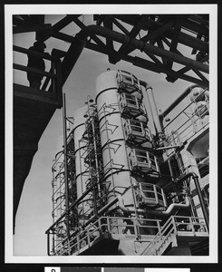 Exterior view of the Shell Oil Company, showing three cylinders on a concrete platform, ca.1940