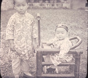 Portrait of child and baby sitting in an infant chair, Changde, Hunan, China, ca.1900-1919