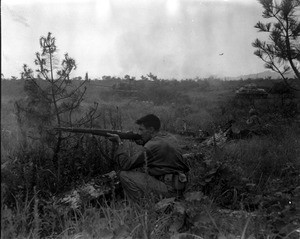 Marine riflemen taking aim in the field in Korea