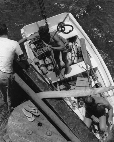Divers and their equipment are lowered to the water in a skiff from R/V Horizon