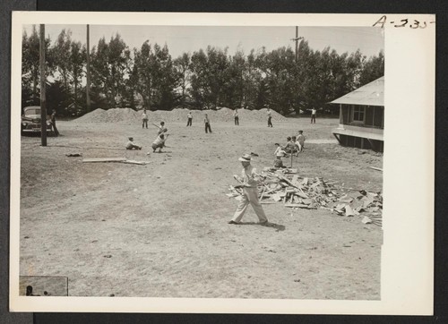 Young evacuees of Japanese descent play baseball on their day of arrival at this assembly center. They will be transferred later to a War Relocation Authority center. Photographer: Albers, Clem Salinas, California
