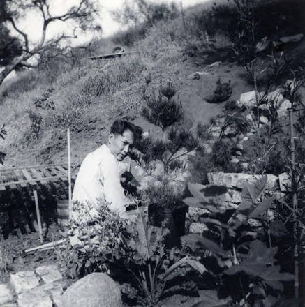 Photo of a man working outside of the back of which it reads "El working on wall step" (Spencer Chan Family)