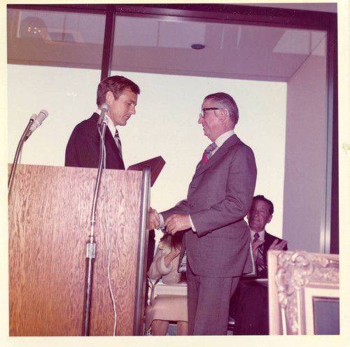 President Banowsky making a presentation to George Elkins