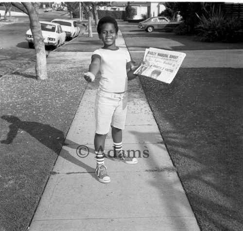 Young boy with newspaper, Los Angeles, 1973