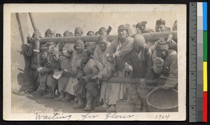 People clustering by a fence, waiting for food, Jiangsu, China, ca.1905-1910
