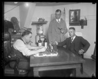 Los Angeles prohibition enforcement officer George Contreras sitting at his desk, with two other unidentified men, circa 1920