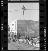 Steve McPeak walking tight rope across Windward Avenue in Venice, Calif., 1979
