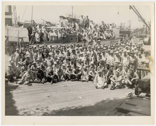 Shipyard employees gather in front of ship
