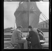 Men sitting in front of docked ship, Hawaiian Rancher, California Labor School