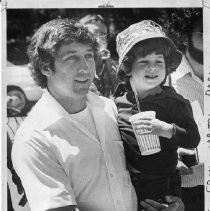 Tom Hayden (Thomas E. Hayden), antiwar and civil rights activist, in Capitol Park, Sacramento. He is holding his son with Jane Fonda, Troy Garity. He was a candidate for U.S. Senator from California (Democratic primary)