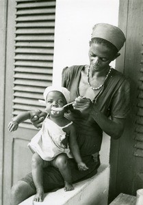 Woman feeding a child, in Ebeigne, Gabon