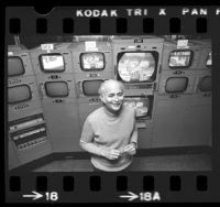 Norman Lear standing before bank of camera monitors showing "All in the Family" in Los Angeles, Calif., 1975