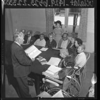 Man conducting an United States immigration class to a group of elderly immigrants at the International Institute of Los Angeles, Calif., 1964