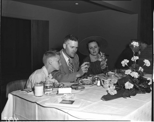Family at luncheon after meter installation? Father is holding a Gold Medalion home coin