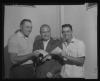 Steve Bilko and Gene Mauch grab a baseball contract from John Holland, Los Angeles, 1956