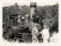 Two men standing in front of a Mt. Tam & Muir Woods locomotive, circa 1925