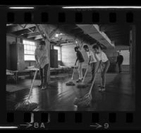 Four boys mopping barracks at Camp Roberts as part of summer camp program, Calif., 1967