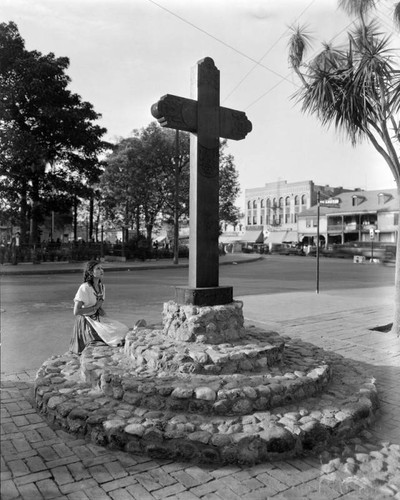 Girl kneeling before a cross