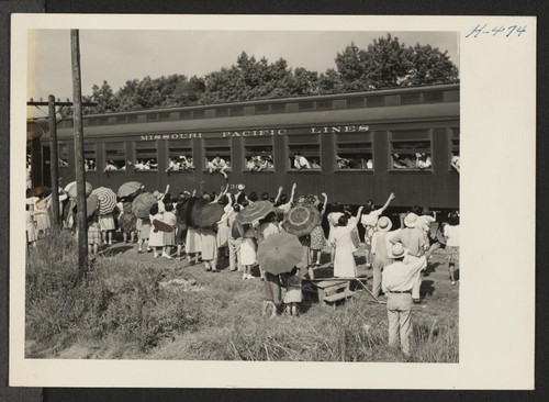 Closing of the Jerome Center, Denson, Arkansas. The whistle blows, the train jerks forward, and Jerome residents awaiting movement to other centers wave to their friends who are en route to Gila River Center. Photographer: Mace, Charles E. Denson, Arkansas
