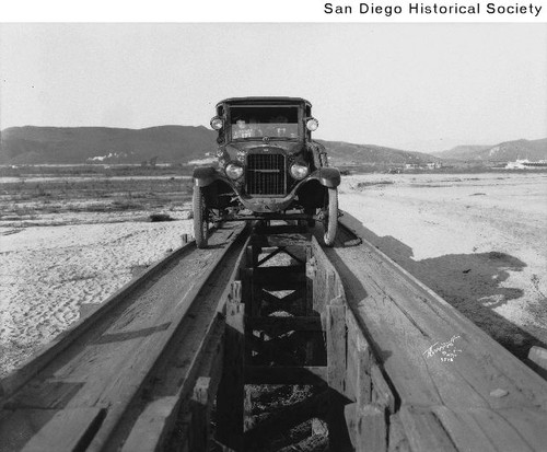 The Overland Touring Sedan on a wooden bridge at the U.S.-Mexico border