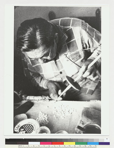 Leonard Bateman, beadmaker; close-up placing drill
