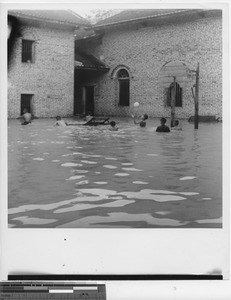 Children playing basketball in the flood at Wuzhou, China, 1950