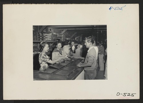 Manzanar, Calif.--Ice cream bar passes hands in the community store at Manzanar, a War Relocation Authority center where evacuees of