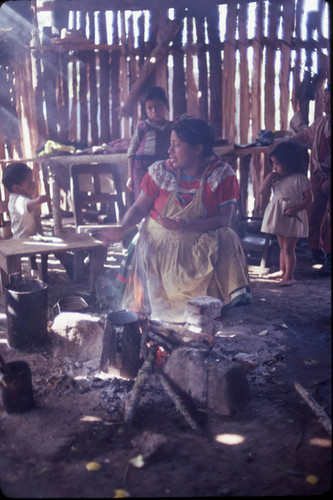 Guatemalan refugees sit in front of a fire, Cuauhtémoc, 1983-01