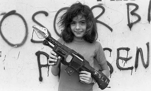 Young girl holding a toy rifle, Nicaragua, 1979