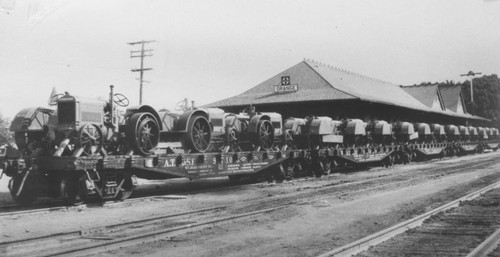 Santa Fe Depot with railroad car loaded with shipment of tractors for the M. Eltiste Company, Orange, California, 1922