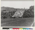 Berkeley campus. Card stunts started at the Big Game between California and Stanford in 1908 using colored hats. Photo shows first stunts using stiff cardboard in 1915 in Berkeley rooting section