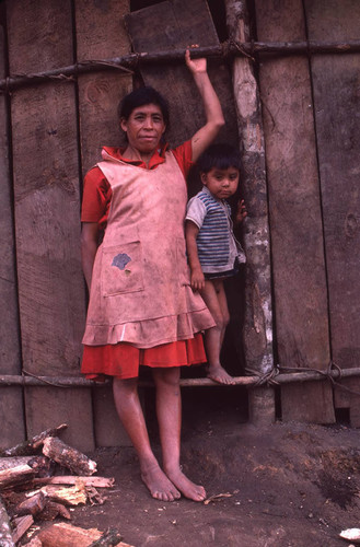 Guatemalan refugees lean against a wooden fence, Tziscao, 1983