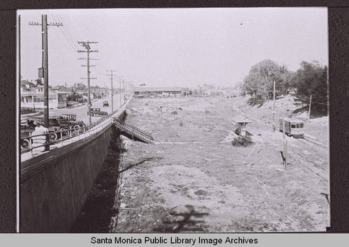 Looking east in the arroyo (south of Colorado Avenue) showing a Pacific Electric car traveling west, Santa Monica, Calif