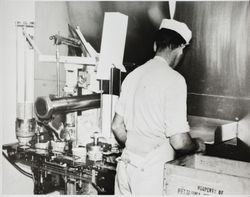 Wes Reid filling boxes with cartons of cottage cheese at the Petaluma Cooperative Creamery, about 1955