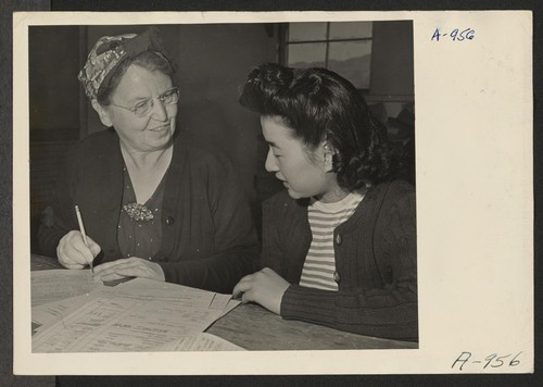 Mrs. Chlde Zimmerman, clerk, aiding Fumi Ido in registering for indefinite leave. Present occupation: kitchen work. Former occupation: cannery work. Former residence: Terminal Island, Calif. Photographer: Stewart, Francis Manzanar, California