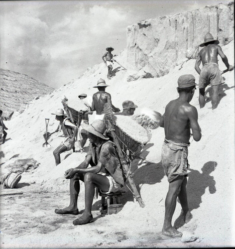 Laborers gathering and hauling sand