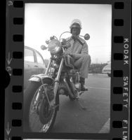 Basketball player and commentator Bill Russell seated on motorcycle in Los Angeles, Calif., 1973
