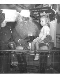 Unidentified Santa with a girl on his lap at Tomasini Hardware, Petaulma, California, 1936