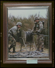 Two soldiers working with wire