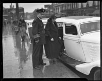 Police Chief James E. Davis and Gertrude Rounsavelle enter police car, Los Angeles, 1935